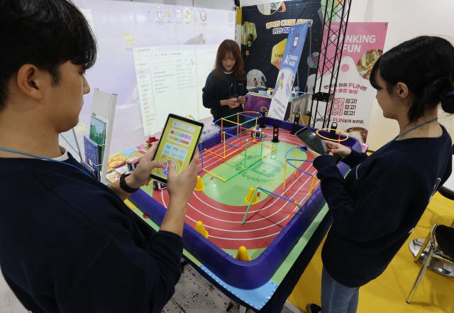 17일 서울 서초구 aT센터에서 열린 '2024 코리아 메타버스 페스티벌'의 한 부스에서 관계자들이 어린이를 위한 코딩 자동차를 시연하고 있다. 연합뉴스